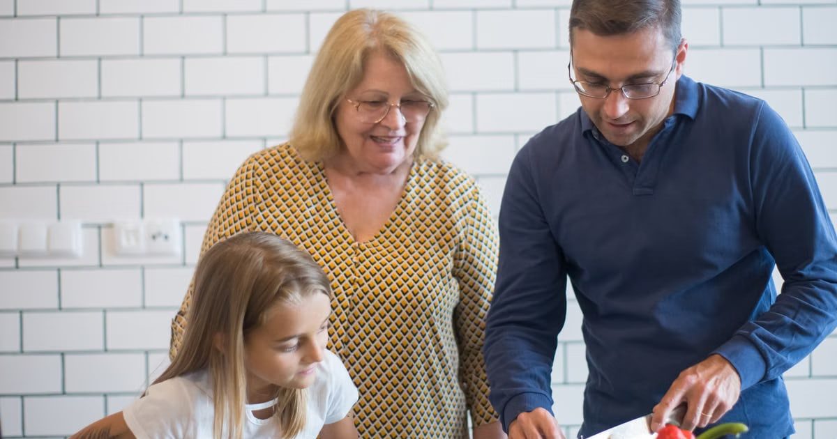 A family happily preparing vegetables together in a modern kitchen.