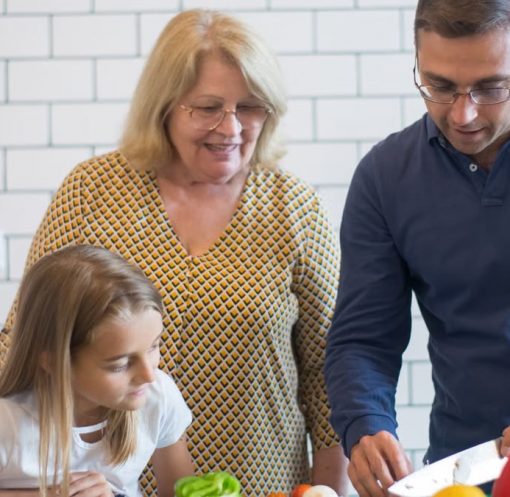 A family happily preparing vegetables together in a modern kitchen.