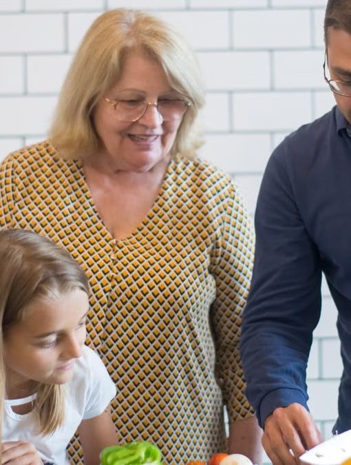A family happily preparing vegetables together in a modern kitchen.
