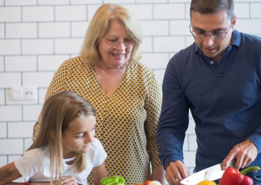 A family happily preparing vegetables together in a modern kitchen.